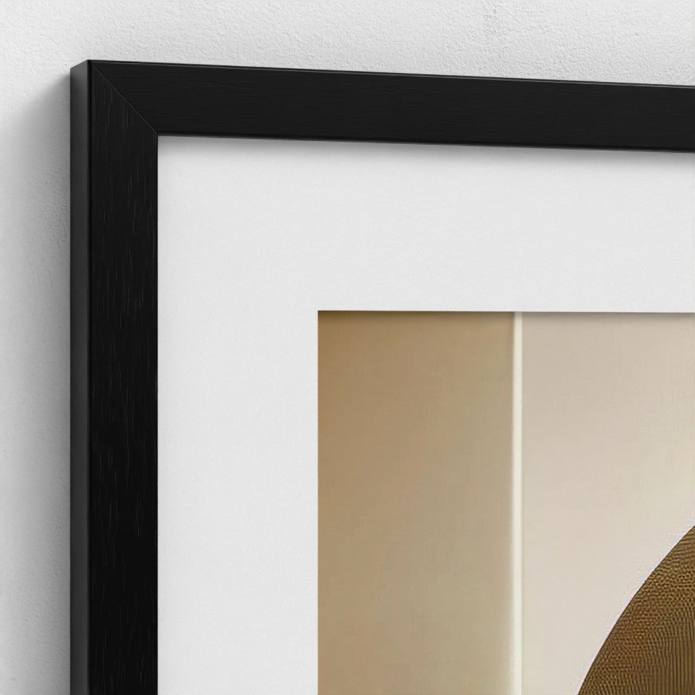 Close-up of a black framed artwork with abstract design on a white wall.