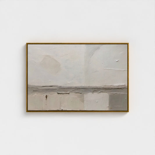Abstract painting in a gold frame on a white wall