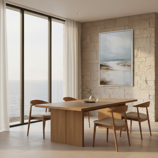 Modern dining room with wooden table and chairs, large windows, and a stone wall with a painting.