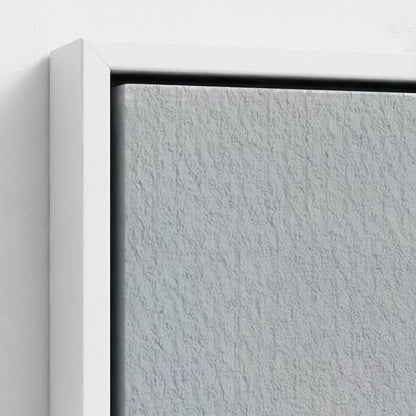 Close-up of a textured gray wall with a white frame.