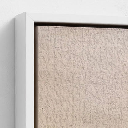 Close-up of a textured beige wall with a white frame.