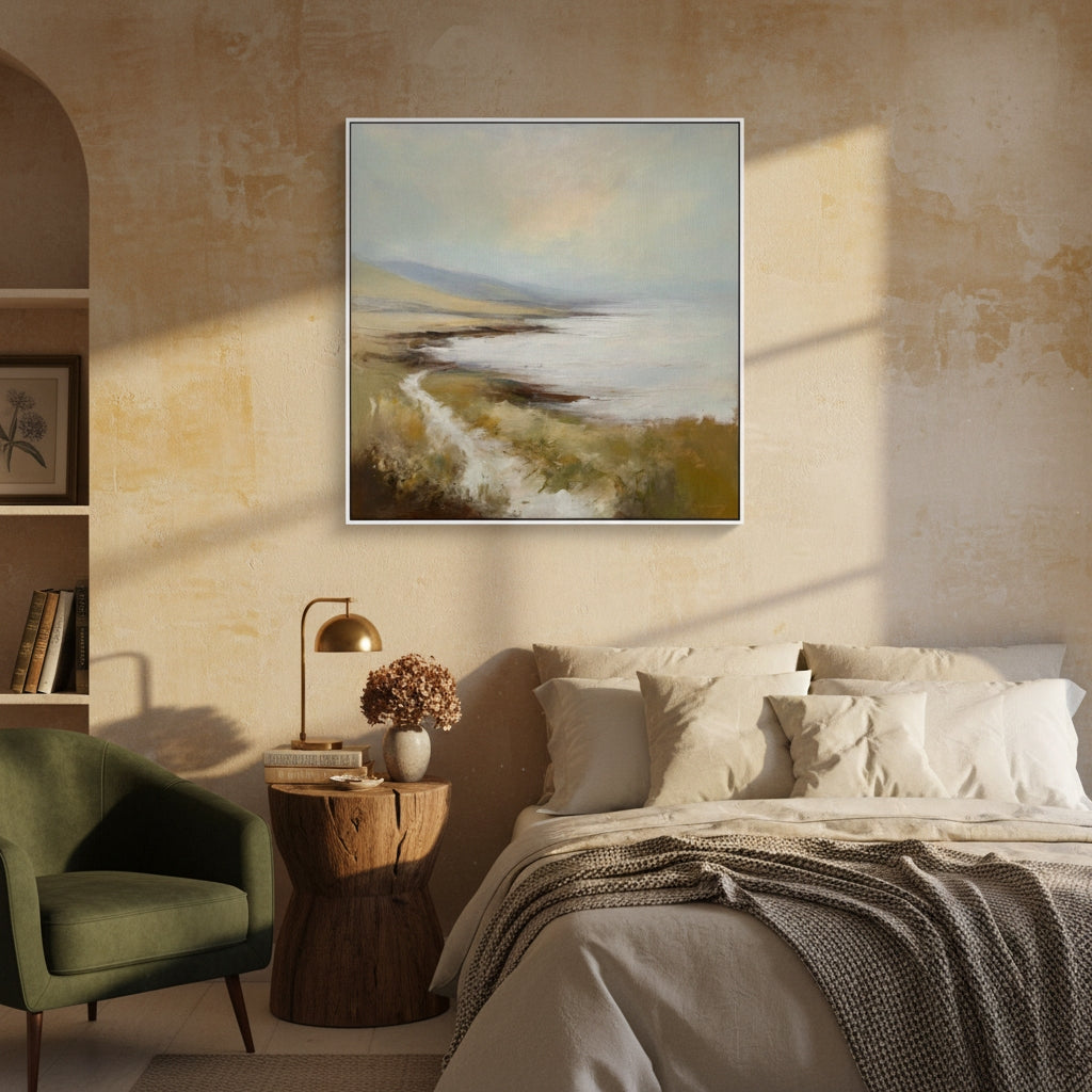 Cozy bedroom with a painting of a landscape above a bed, green armchair, and wooden side table.