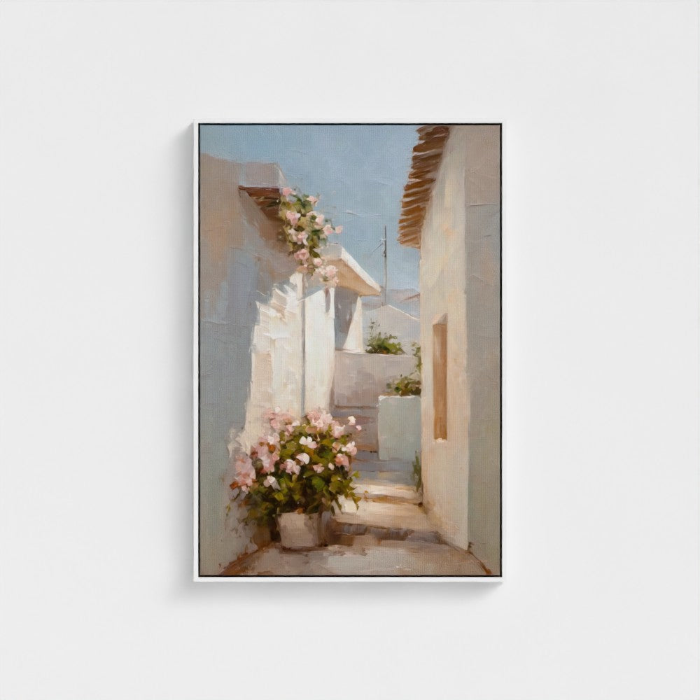Framed artwork of a sunlit alleyway with flowers and white buildings.