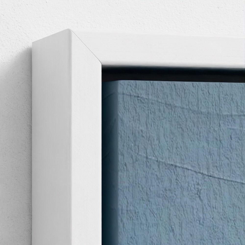 Close-up of a white frame corner with a textured blue wall background
