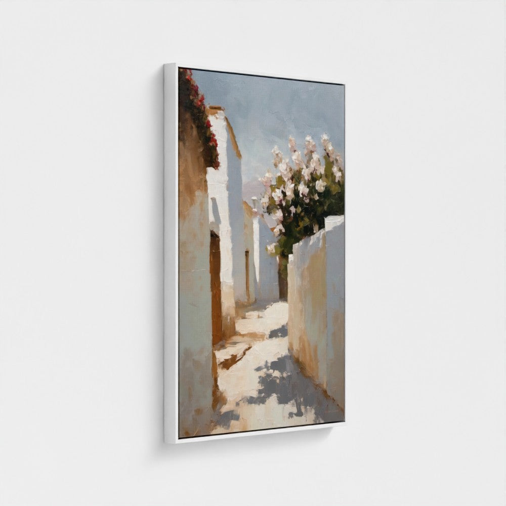 Framed artwork of a sunlit street with white walls and flowers on a light gray background