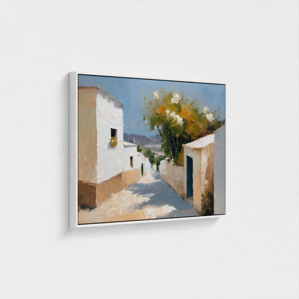 Framed painting of a sunlit street with white buildings and flowers.