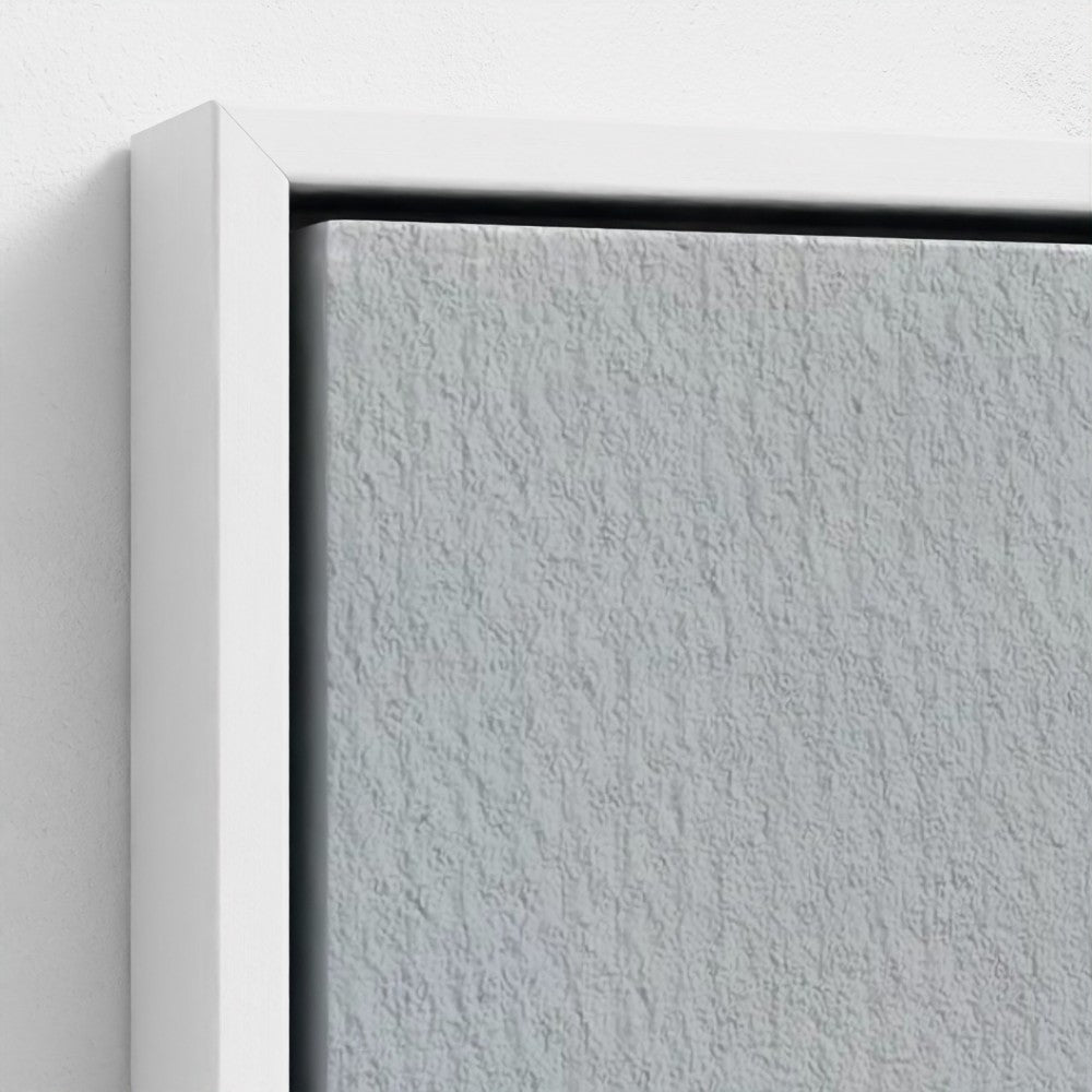 Close-up of a textured gray wall with a white frame.