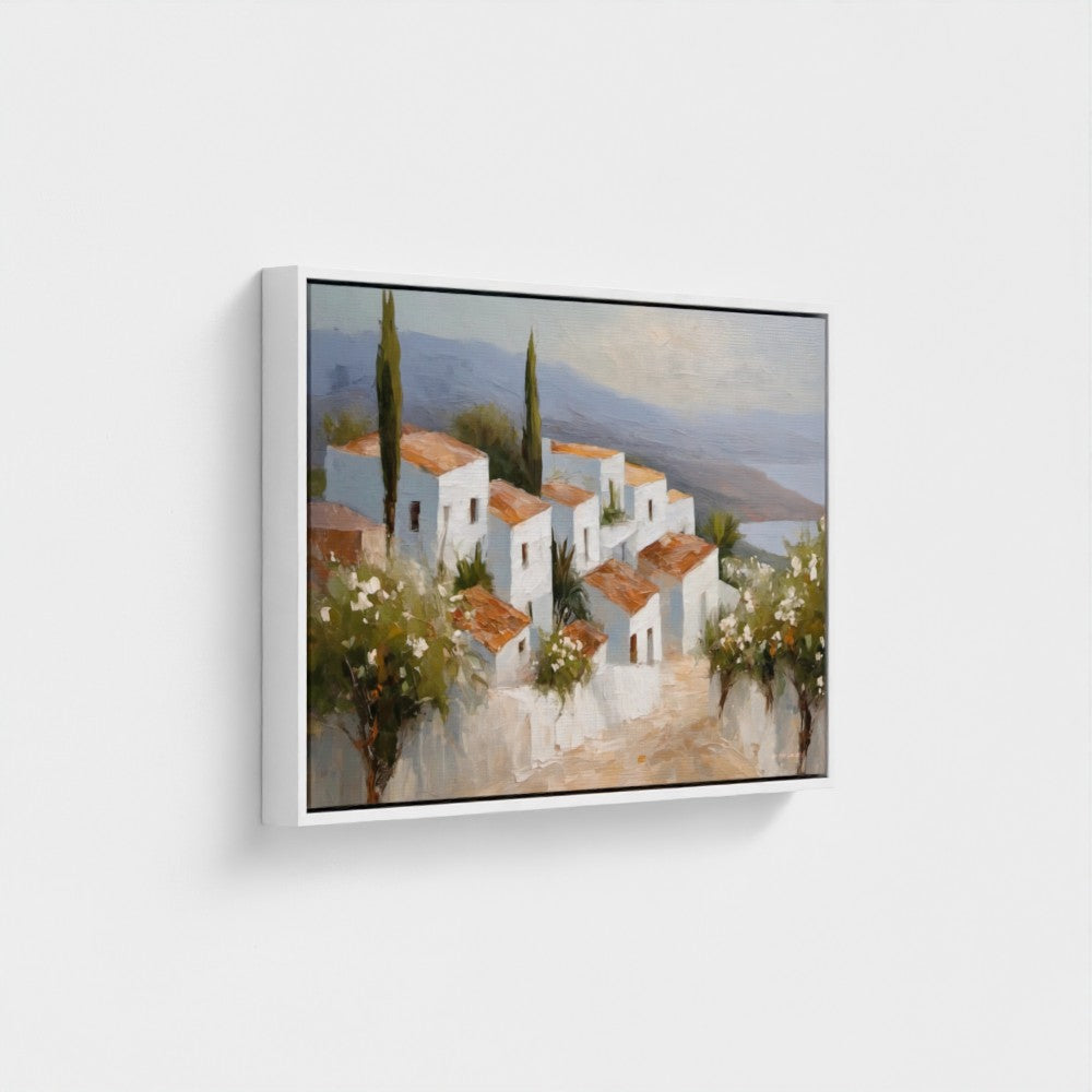 Framed painting of a Mediterranean village scene on a white wall