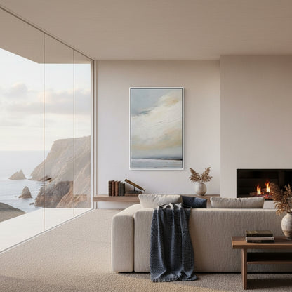 Modern living room with a large window view of the ocean, a sofa with a blanket, and a fireplace.