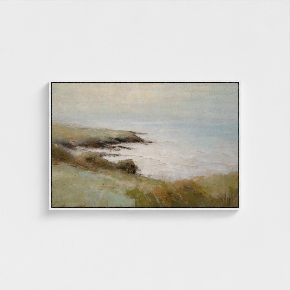 Framed painting of a coastal landscape with a white wall background