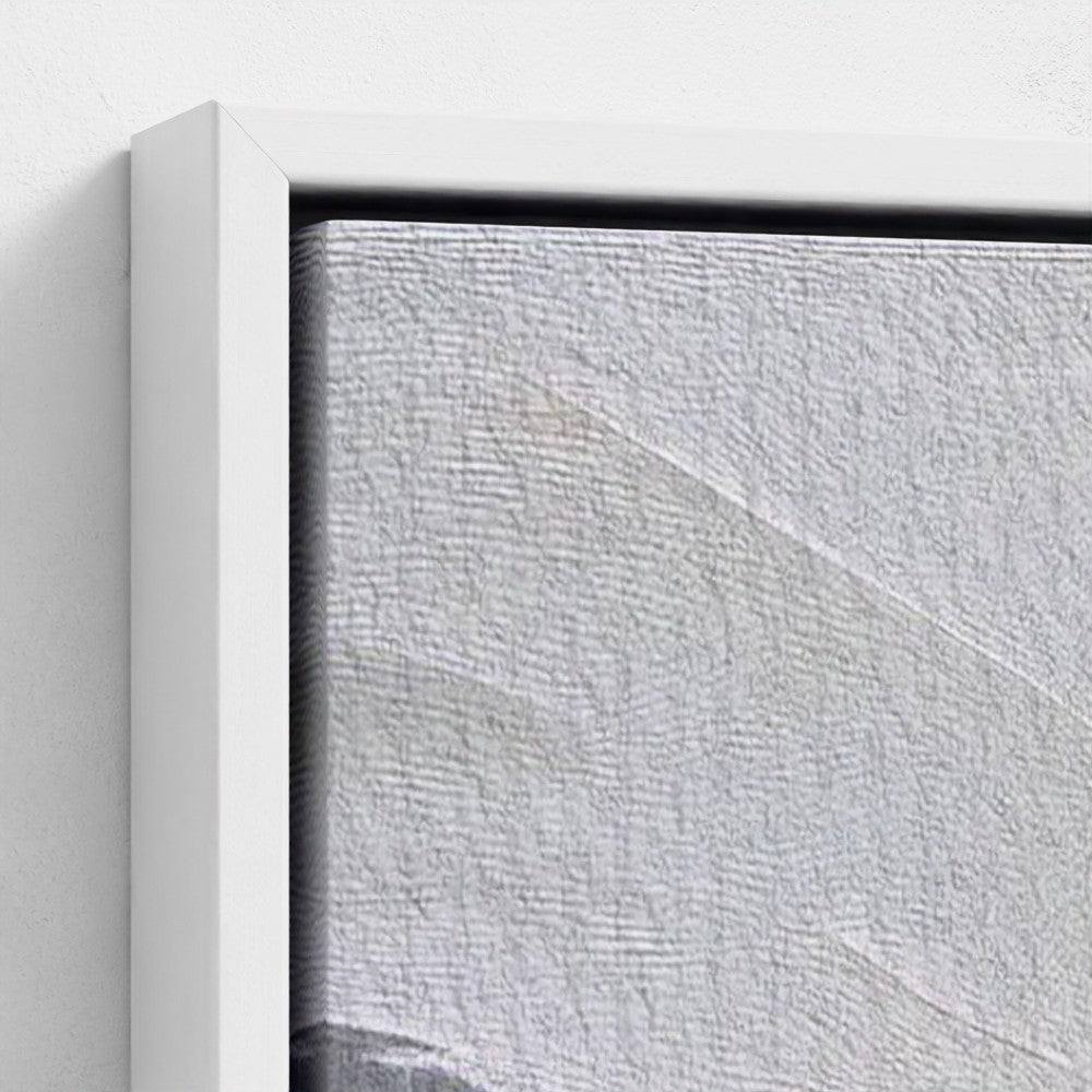 Close-up of a textured gray wall with a white frame.