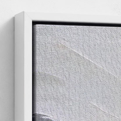 Close-up of a textured gray wall with a white frame.