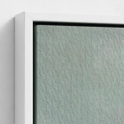 Close-up of a textured light gray wall with a white frame.