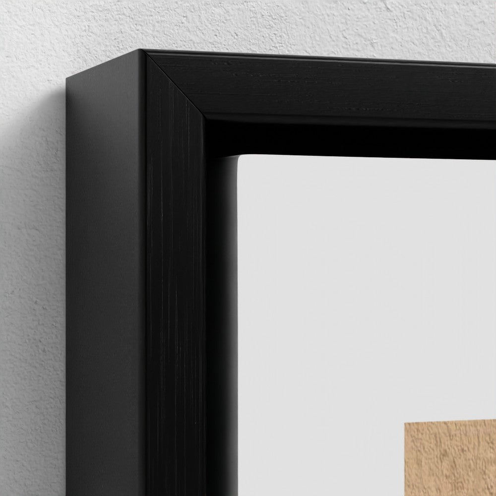 Close-up of a black picture frame on a light gray wall.