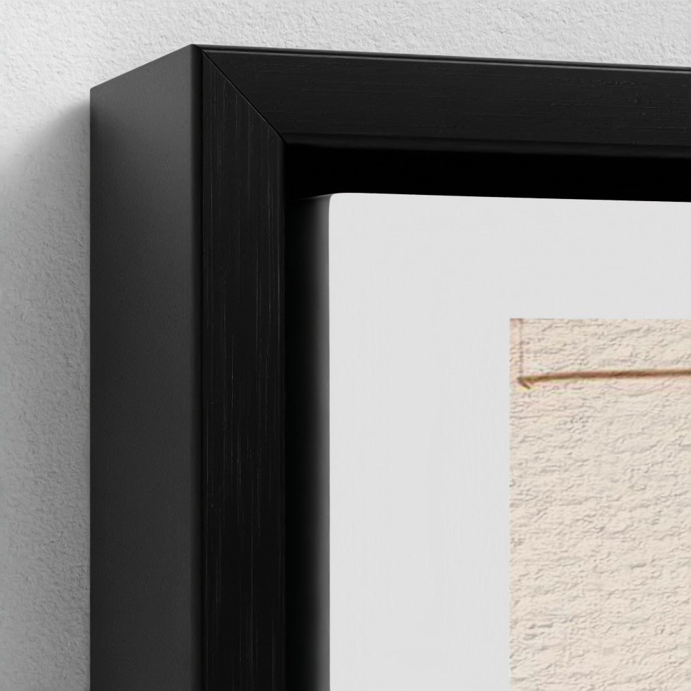 Close-up of a black framed artwork on a light gray wall.