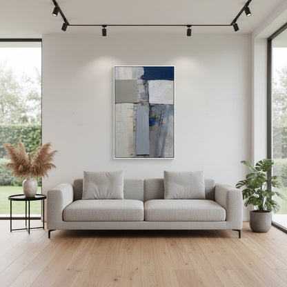 Modern living room with a gray sofa, abstract painting, and plants.