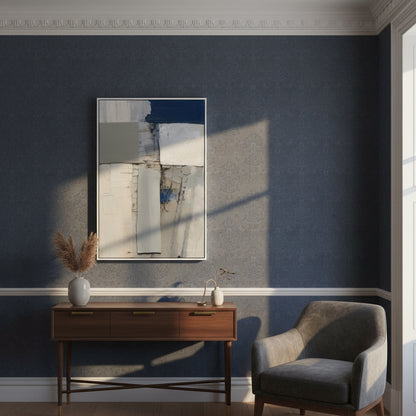 Modern interior with abstract art, console table, and chair against a dark blue wall.