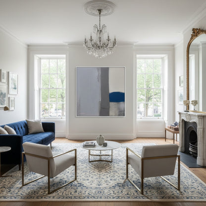 Living room with blue sofa, white chairs, and a chandelier.