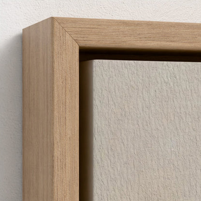 Close-up of a wooden picture frame on a white wall.