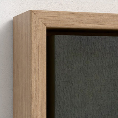 Close-up of a wooden picture frame with a dark gray wall background