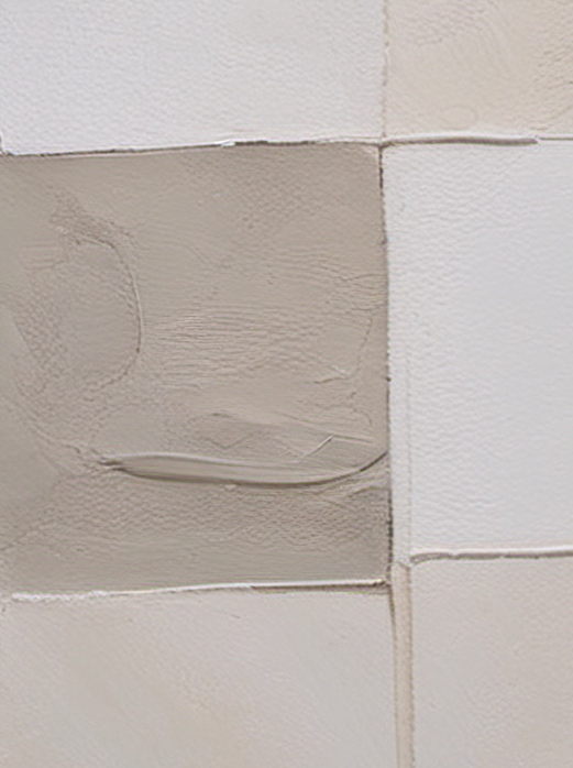 Close-up of tiled wall with a patch of gray paint