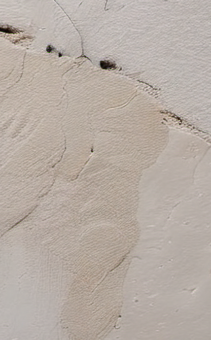 Close-up of textured beige wall with cracks and small stones
