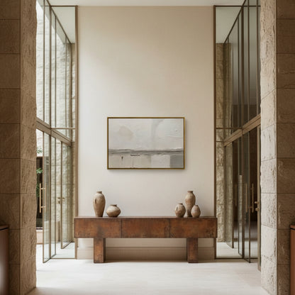 Modern interior with a wooden console table and decorative vases against a neutral wall.