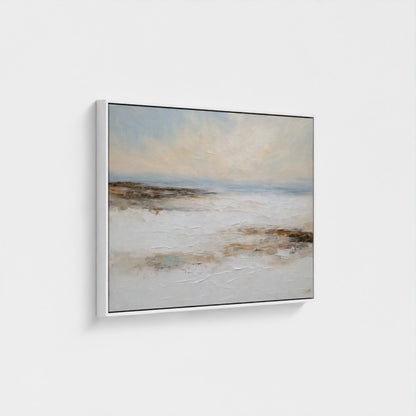 Framed artwork of a landscape with a beach and sky on a white wall