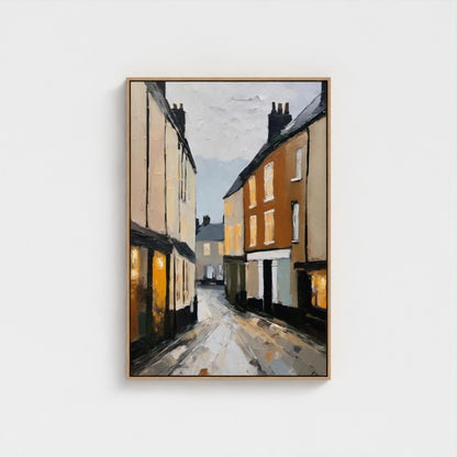 Framed painting of a street scene with houses on a white background