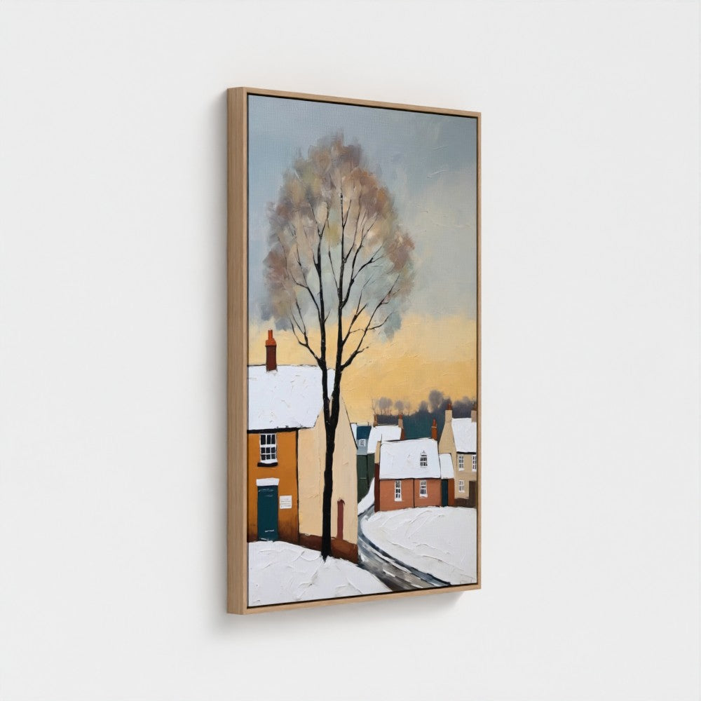 Framed artwork of a snowy village scene with a tree on a white wall.