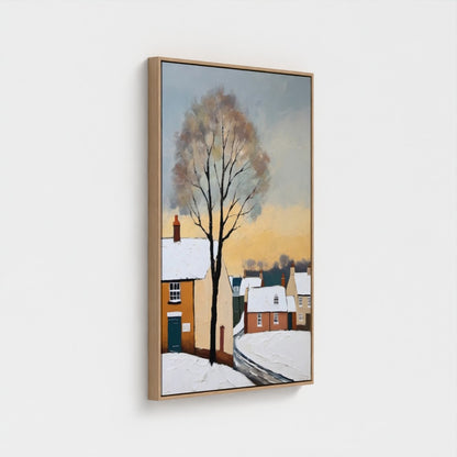 Framed artwork of a snowy village scene with a tree on a white wall.