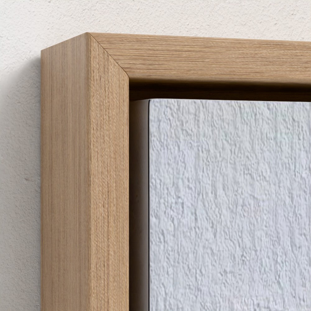 Close-up of a wooden picture frame on a textured white wall.