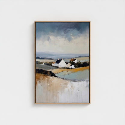 Framed artwork of a landscape with houses and fields on a white wall
