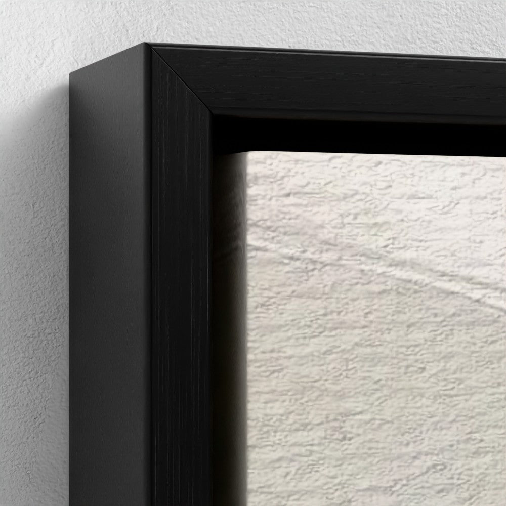 Close-up of a black picture frame corner on a textured white wall.