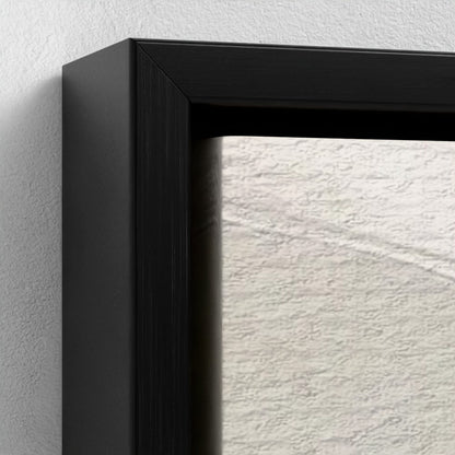 Close-up of a black picture frame corner on a textured white wall.