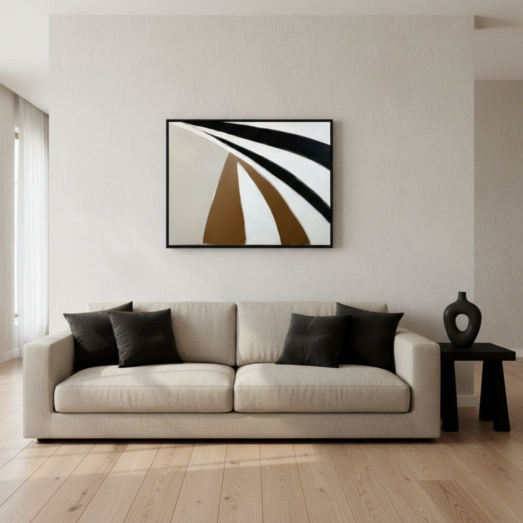 Modern living room with a beige sofa, black cushions, and abstract art on the wall.