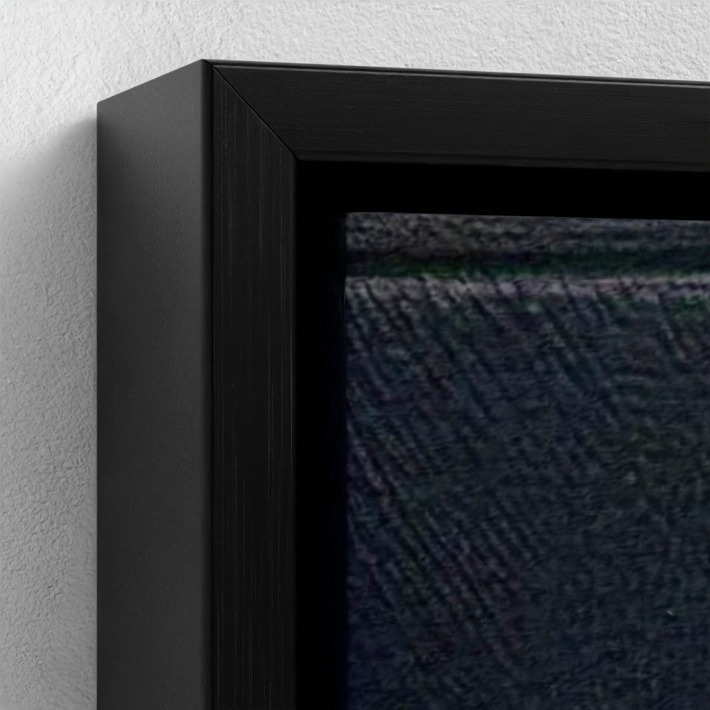 Close-up of a black framed artwork on a textured wall.