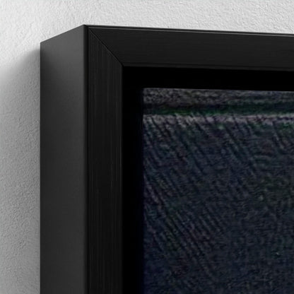 Close-up of a black framed artwork on a textured wall.