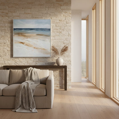 Modern living room with a beige sofa, abstract painting, and stone wall.