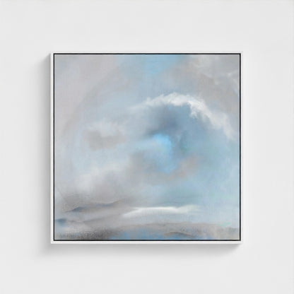 Framed artwork of a cloud in a blue sky on a white wall