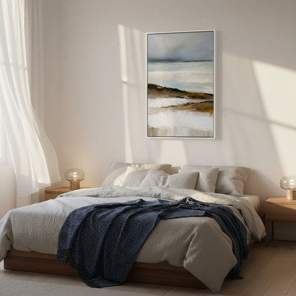 Bedroom with a bed, blue blanket, and framed artwork on the wall.