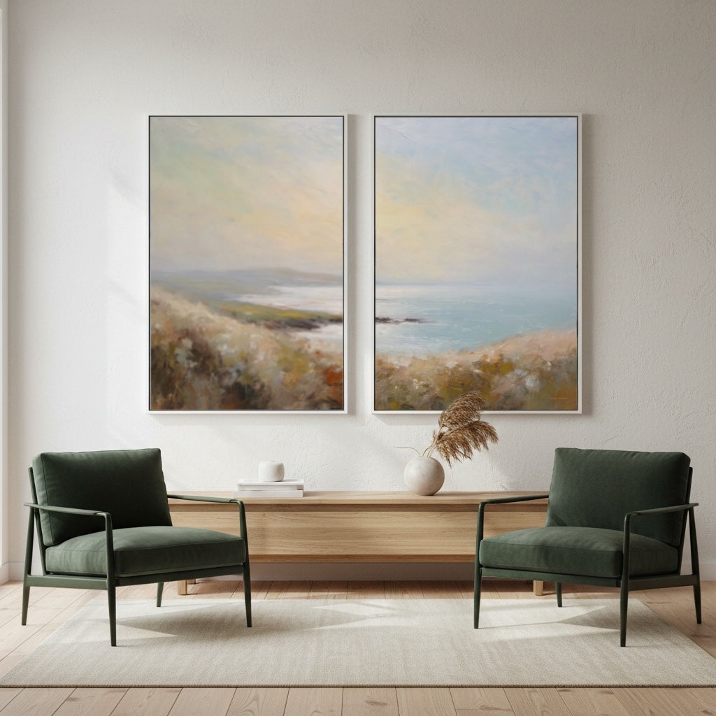 Two green armchairs in a living room with two landscape paintings on the wall.