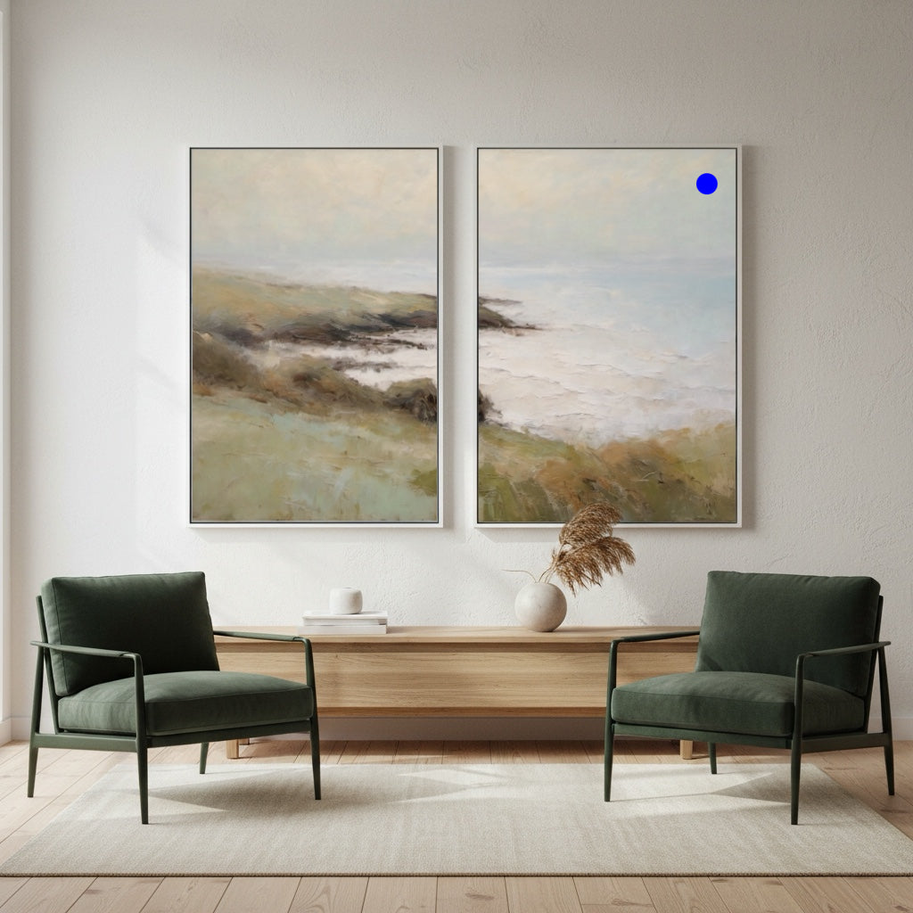 Two green armchairs in a room with two large landscape paintings on the wall.