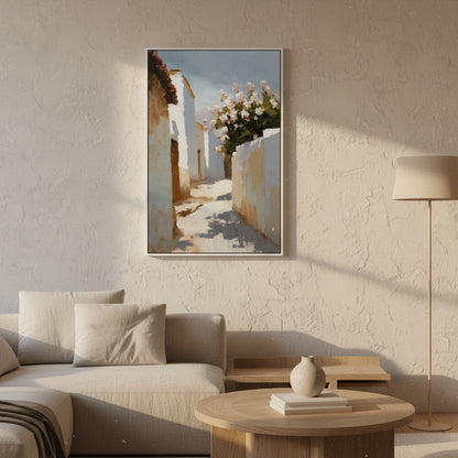 Framed artwork of a sunlit street scene with white buildings and flowers, hanging on a textured wall above a sofa.