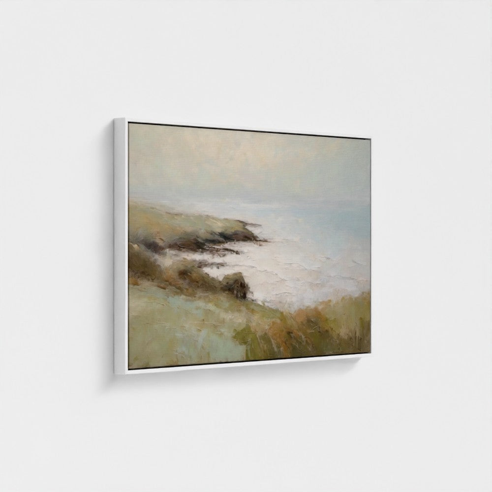 Framed artwork of a landscape with a body of water and hills on a white wall.