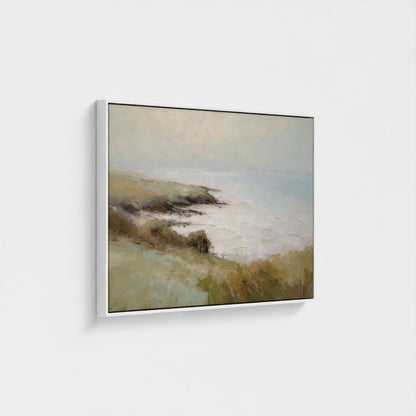 Framed artwork of a landscape with a body of water and hills on a white wall.
