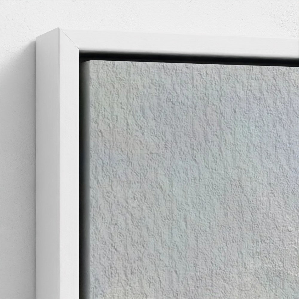 Close-up of a textured gray wall with a white frame.